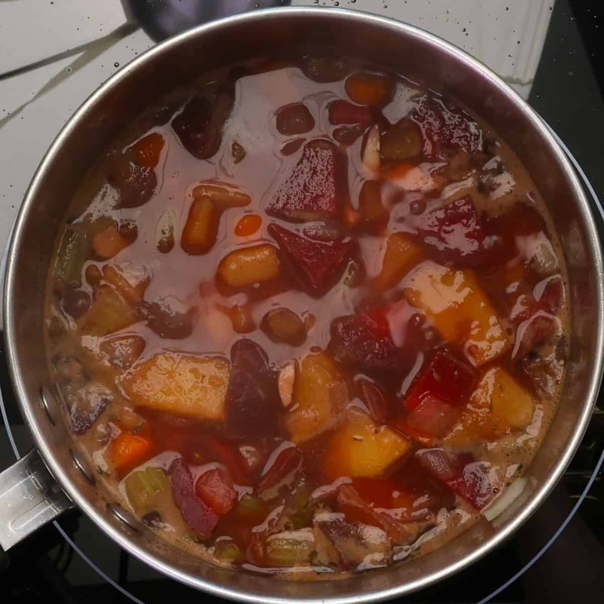 a single serving of borscht cooking in a small pot.