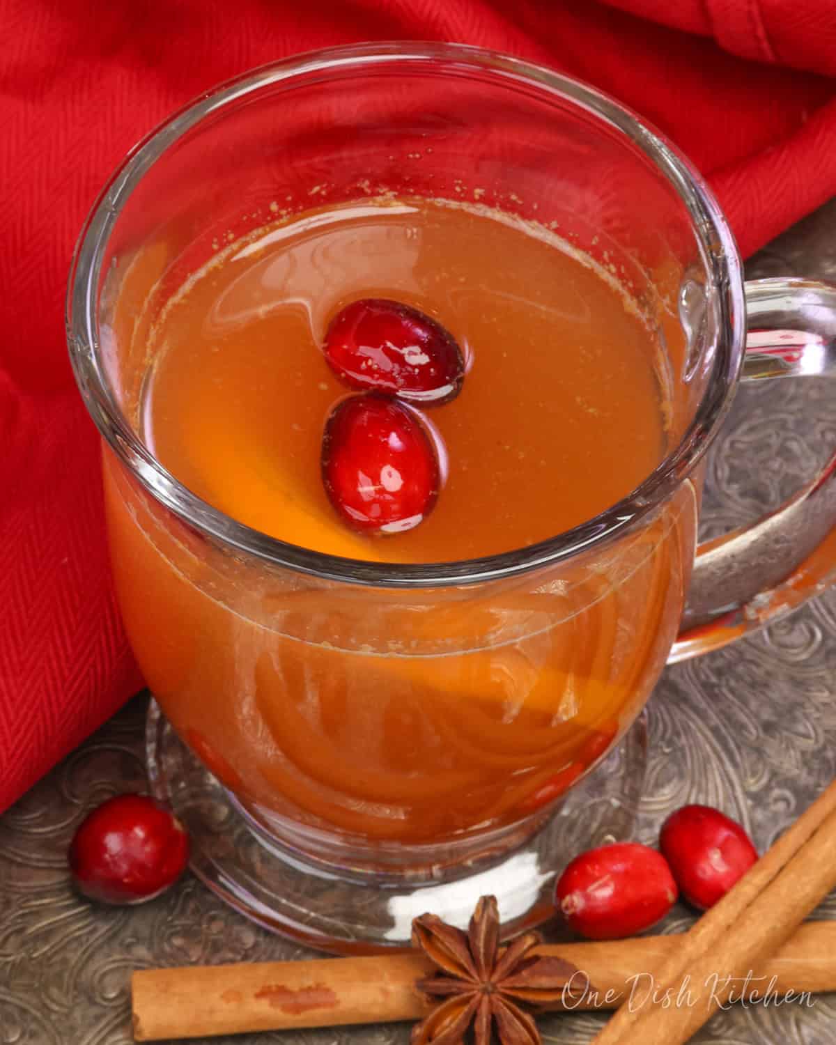 a mug of hot mulled cider with cranberries, oranges, cinnamon and star anise.
