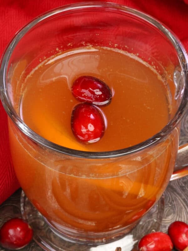 a mug of hot mulled cider with cranberries, oranges, cinnamon and star anise.
