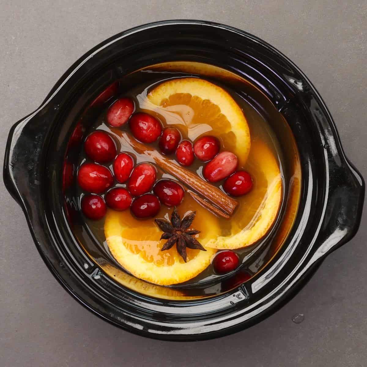 slow cooker mulled cider in the base of a small slow cooker.
