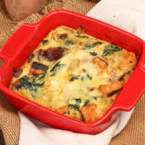 a single serving crustless sweet potato quiche with roasted sweet potatoes, greens, and cheese.