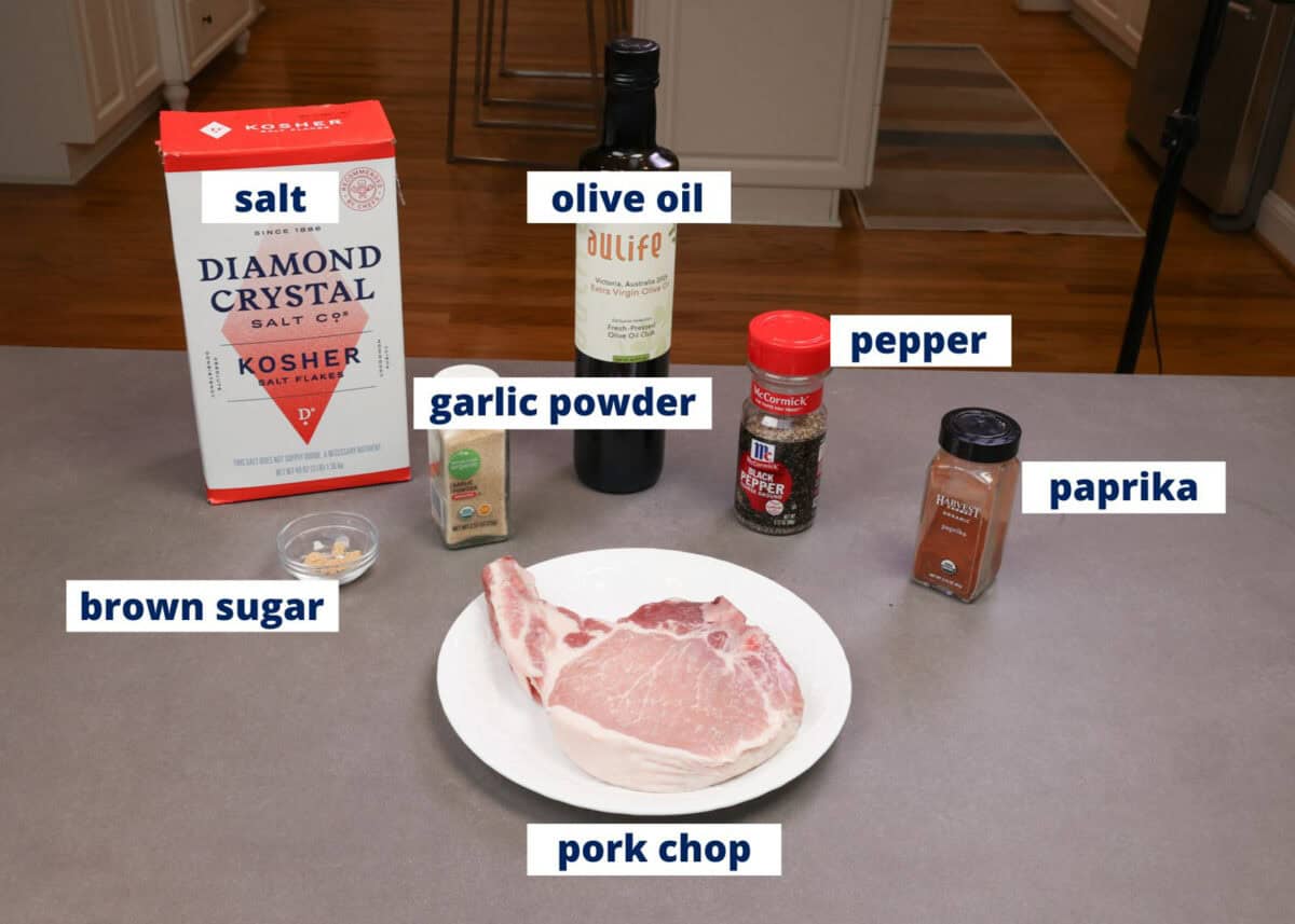 ingredients needed to make a single baked bone in pork chop assembled on a kitchen counter.