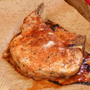 one baked bone in pork chop with homemade pork chop seasoning on a baking sheet.