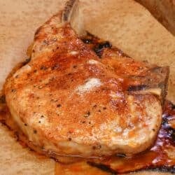 one baked bone in pork chop with homemade pork chop seasoning on a baking sheet.