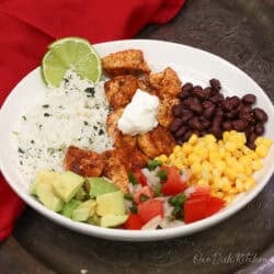 a chicken burrito bowl made with seasoned chicken, rice, avocado, corn and black beans.