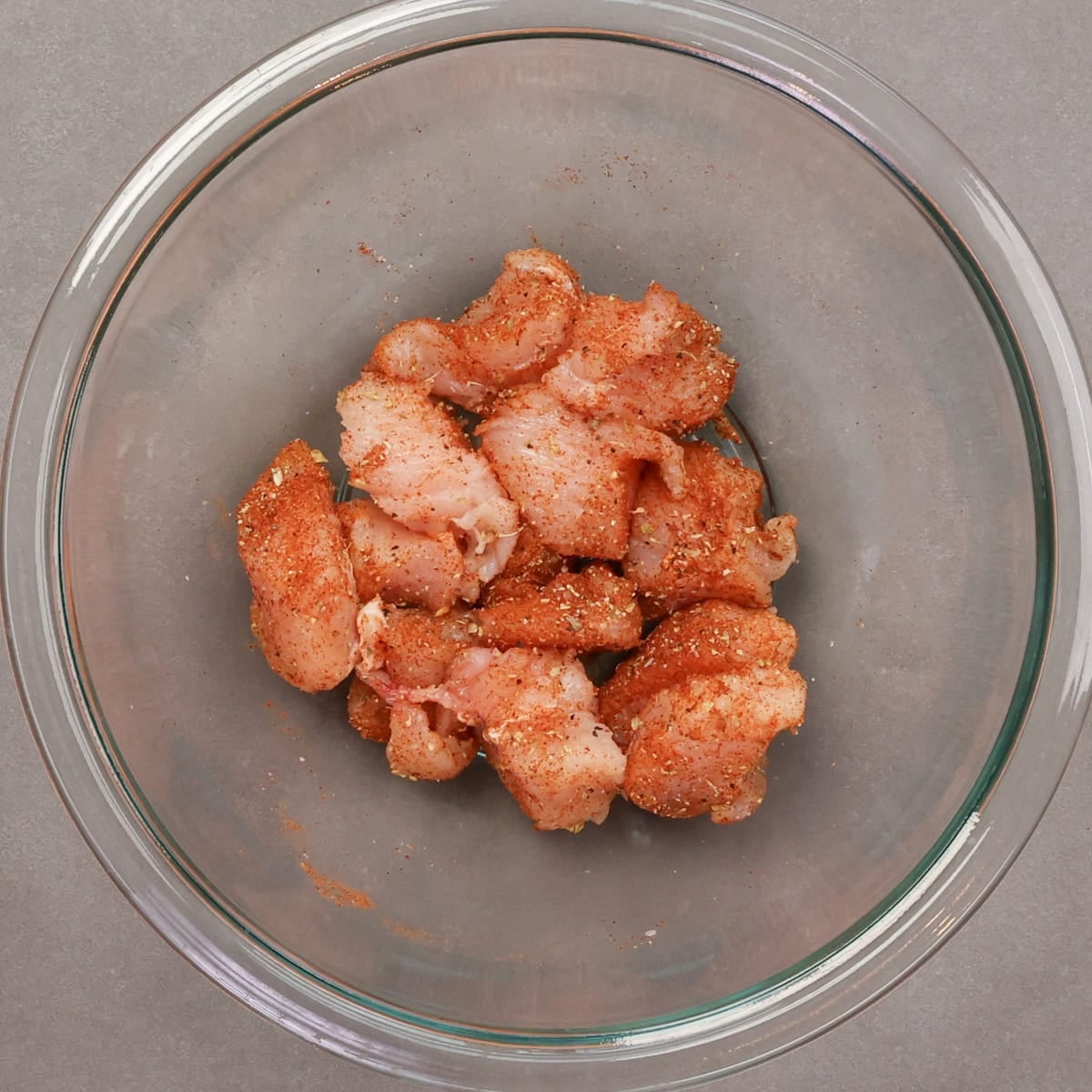 uncooked seasoned chicken in a bowl.