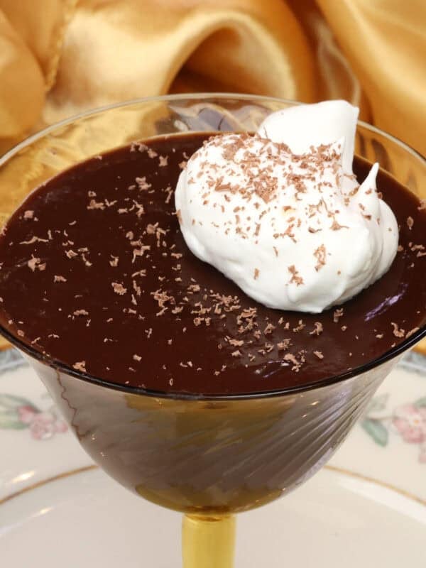 Chocolate pot de crรจme for one served in a dessert dish topped with whipped cream.