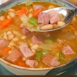 a single bowl of ham and bean soup with carrots and celery.