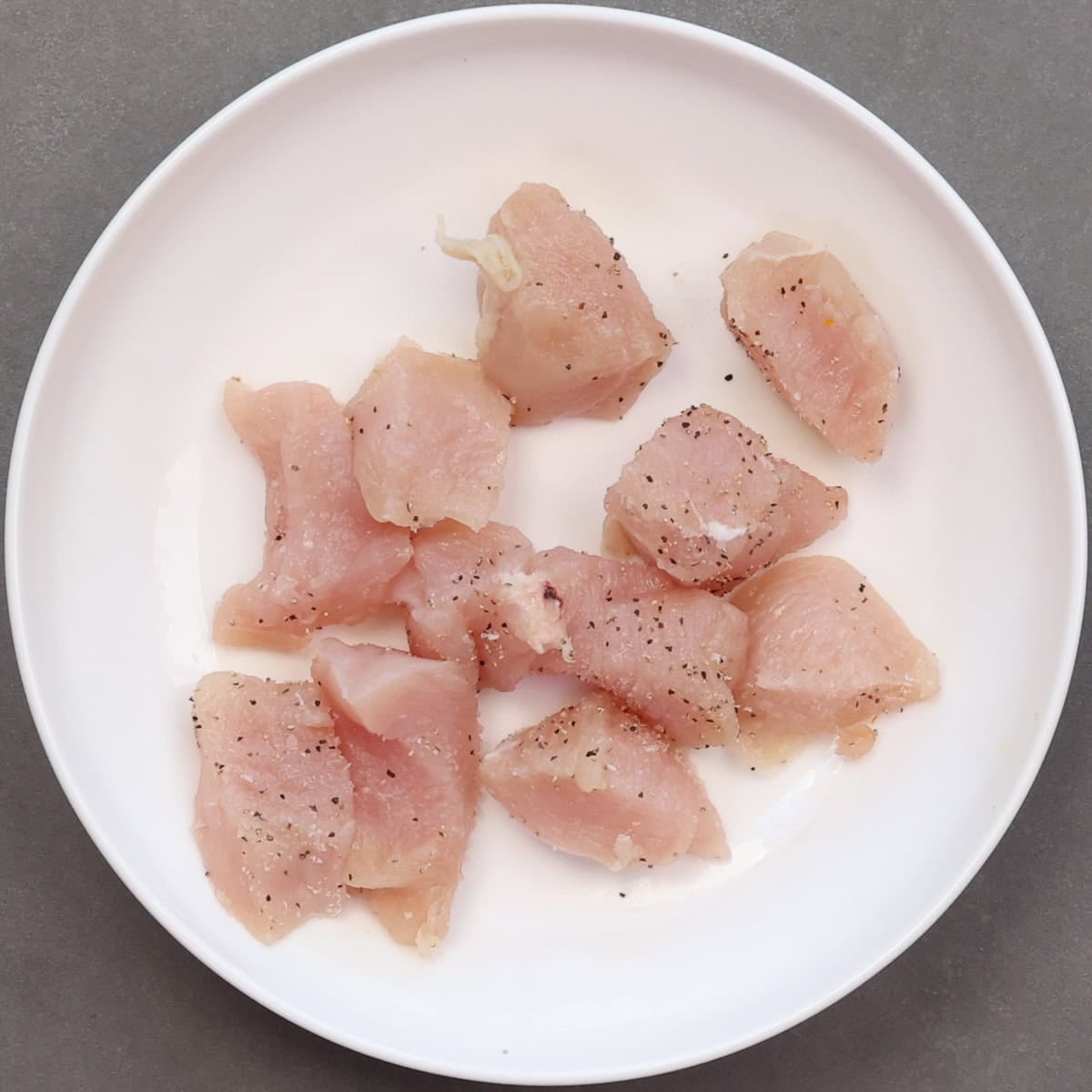 one boneless skinless chicken breast cut into cubes and seasoned with salt and pepper.