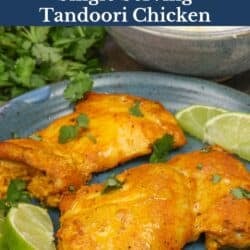 a single serving of tandoori chicken made with two boneless skinless chicken thighs on a blue plate.