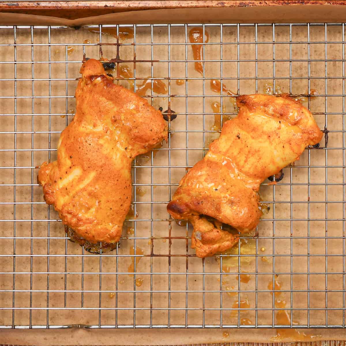 single serving baked chicken tandoori on a wire rack on a baking sheet.